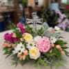 A gentle and comforting arrangement with soft pastel blooms and fresh greenery