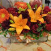 Orange and red mixed flower arrangement in a rectangular box