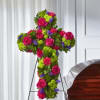 Cross-shaped floral tribute with pink roses and bright mixed blooms