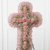 Pink floral cross on an easel with ruffled trim