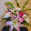 Pink lilies and roses with white chrysanthemums in a glass vase