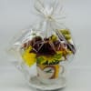 Bouquet of yellow and burgundy flowers in a decorative mug, wrapped in clear cellophane
