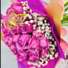 Bouquet of pink roses with white baby's breath wrapped in bright purple paper