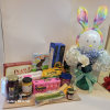 Gift basket with flowers and snacks beside a bunny decoration