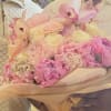 Pink and cream bouquet with orchids, roses, and hydrangeas wrapped in beige paper