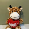 Plush giraffe holding a red heart with the word LOVE