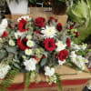 Red and white floral arrangement with roses, daisies, and carnations