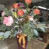 Bouquet of orange roses and pink carnations in a vase