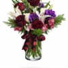 Bouquet of red roses, white lilies, and purple flowers in a glass vase