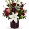 Mixed bouquet with red roses, white lily, and purple blooms in a dark vase