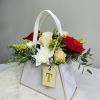 White handled gift bag with red and white roses and a white chrysanthemum