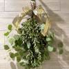 Hanging bundle of green eucalyptus tied with a gold ribbon