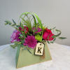 Mixed bouquet in a green gift box with a letter tag