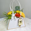 Flower arrangement in a white gift bag with yellow, orange, and white blooms