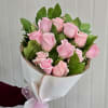 Long-stemmed hot-pink roses hand-tied with greenery, white paper wrap, and pink organza