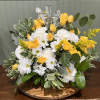 Yellow roses and white daisies arranged on a wooden tray with a silver cross