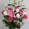 Pink lilies and roses in a clear glass vase