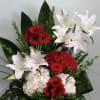 Red and white floral arrangement in a red container