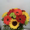 Bouquet of red, orange, and yellow gerbera daisies in a glass vase