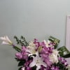 Pink and white floral arrangement in a vase with orchids and lilies