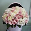 Pink roses and white hydrangeas in a round pink hatbox