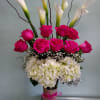 Pink roses and white calla lilies arranged in a glass vase