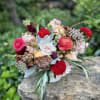 Mixed bouquet of pink, red, and white flowers in a low vase