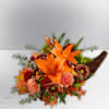 Thanksgiving Cornucopia arrangement featuring orange lilies, carnations, Daisies, and fall filler flowers.