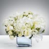 White floral arrangement in a square glass vase