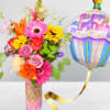 Colorful mixed flower bouquet with a birthday balloon in a decorated vase