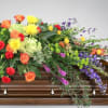 Colorful floral spray arranged on a wooden casket