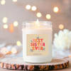 Lit scented candle in a glass jar with a "Best Sister Ever" label