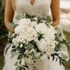 Bride holding a white rose bouquet with greenery