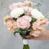 Pale pink roses take center stage in this pastel prom bouquet, a