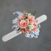 Soft peac hroses clustered into a compact Peach corsage create an instantly