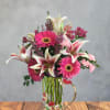 Bright pink gerbera daisies and white-and-pink lilies set the tone in this