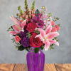 Bright, lush pink lilies reach outward over a garden of hot pink
