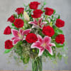 Red roses and pink lilies in a clear glass vase