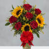 Red roses and sunflowers in a glass vase with a red bow
