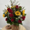 Bouquet of red roses and yellow sunflowers in a painted ceramic vase