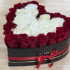Heart-shaped box of red roses and white carnations with a red ribbon