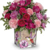 Pink and purple bouquet in a square glass vase with bird artwork