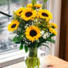 Bouquet of yellow sunflowers in a clear glass vase