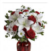Red roses and white lilies in a red glass vase