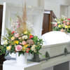 Floral casket spray with pink, yellow, and white flowers