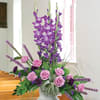Purple and pink floral arrangement in a white vase