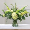 Green floral arrangement in a clear glass vase
