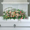 Pastel floral arrangement on a white casket