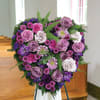 Heart-shaped purple and pink floral spray on an easel
