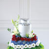 Floral urn arrangement with red roses, blue hydrangeas, and white lilies